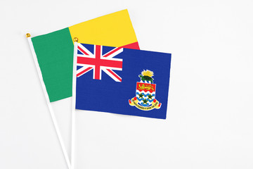 Cayman Islands and Benin stick flags on white background. High quality fabric, miniature national...