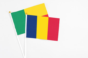 Chad and Benin stick flags on white background. High quality fabric, miniature national flag. Peaceful global concept.White floor for copy space.