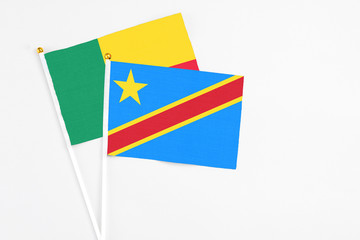Congo and Benin stick flags on white background. High quality fabric, miniature national flag. Peaceful global concept.White floor for copy space.