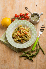 Pasta with pesto sauce green peas and fresh tomatoes