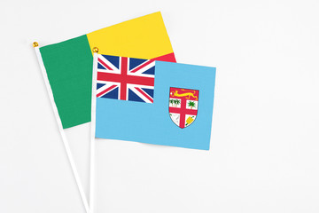 Fiji and Benin stick flags on white background. High quality fabric, miniature national flag. Peaceful global concept.White floor for copy space.