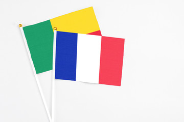 France and Benin stick flags on white background. High quality fabric, miniature national flag. Peaceful global concept.White floor for copy space.