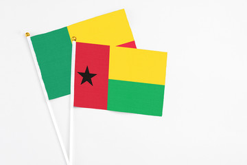 Guinea Bissau and Benin stick flags on white background. High quality fabric, miniature national flag. Peaceful global concept.White floor for copy space.