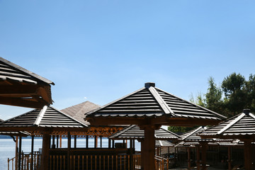 Wooden umbrellas on a deserted beach in low season.