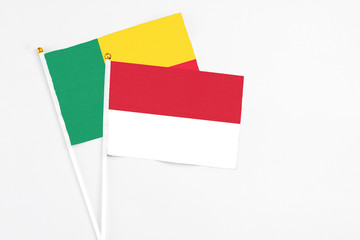 Indonesia and Benin stick flags on white background. High quality fabric, miniature national flag. Peaceful global concept.White floor for copy space.