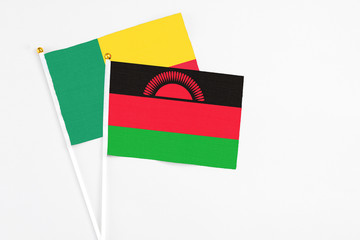 Malawi and Benin stick flags on white background. High quality fabric, miniature national flag....