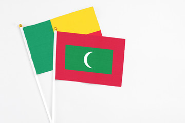 Maldives and Benin stick flags on white background. High quality fabric, miniature national flag. Peaceful global concept.White floor for copy space.