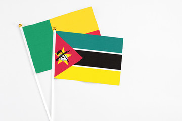 Mozambique and Benin stick flags on white background. High quality fabric, miniature national flag. Peaceful global concept.White floor for copy space.