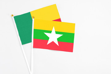 Myanmar and Benin stick flags on white background. High quality fabric, miniature national flag. Peaceful global concept.White floor for copy space.