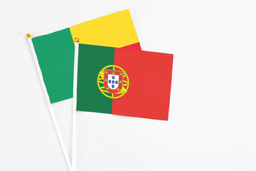 Portugal and Benin stick flags on white background. High quality fabric, miniature national flag....