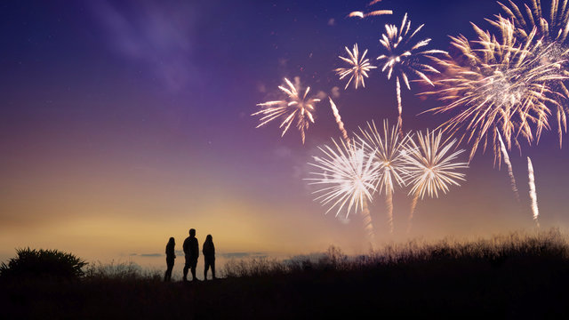 The silhouette image of people looks at the fireworks.