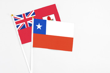 Fototapeta premium Chile and Bermuda stick flags on white background. High quality fabric, miniature national flag. Peaceful global concept.White floor for copy space.