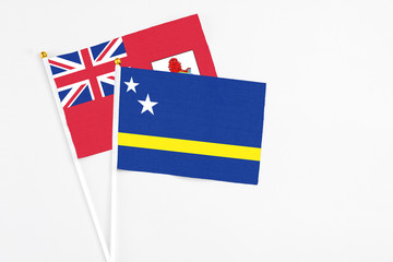 Curacao and Bermuda stick flags on white background. High quality fabric, miniature national flag. Peaceful global concept.White floor for copy space.