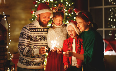 happy family mother, father and children celebrate Christmas and new year, light sparklers.