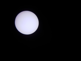 sun through a solar filter and telescope with planet Mercury