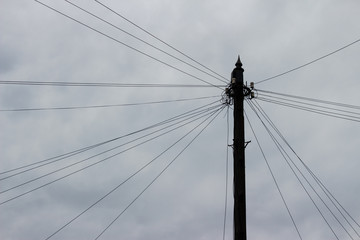 Fototapeta premium Old wooden electrical pole with lot of wires and many cables, power line chaos, cobweb