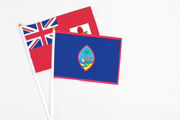 Guam and Bermuda stick flags on white background. High quality fabric, miniature national flag. Peaceful global concept.White floor for copy space.
