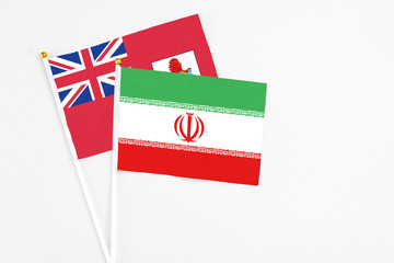 Iran and Bermuda stick flags on white background. High quality fabric, miniature national flag. Peaceful global concept.White floor for copy space.