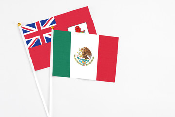 Mexico and Bermuda stick flags on white background. High quality fabric, miniature national flag. Peaceful global concept.White floor for copy space.