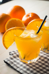 Photo of fresh orange juice in the glass jar. Summer healthy organic drink concept. Cold beverages with ice and orange fruits.