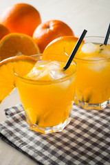 Photo of fresh orange juice in the glass jar. Summer healthy organic drink concept. Cold beverages with ice and orange fruits.