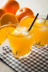 Photo of fresh orange juice in the glass jar. Summer healthy organic drink concept. Cold beverages with ice and orange fruits.