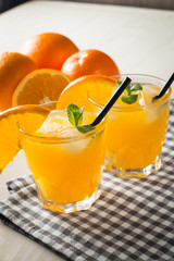 Photo of fresh orange juice in the glass jar. Summer healthy organic drink concept. Cold beverages with ice and orange fruits.