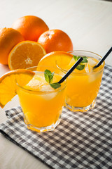 Photo of fresh orange juice in the glass jar. Summer healthy organic drink concept. Cold beverages with ice and orange fruits.