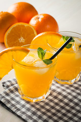 Photo of fresh orange juice in the glass jar. Summer healthy organic drink concept. Cold beverages with ice and orange fruits.