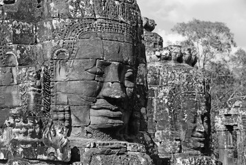 Black and white picture of Ancient stone faces of Bayon temple in complex Angkor Wat in Siem Reap,...
