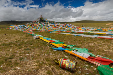 TIBETAN PLATEAU, TIBET / CHINA - August 1, 2019: Several strings of colorful prayer flags in the...