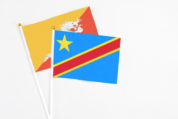 Congo and Bhutan stick flags on white background. High quality fabric, miniature national flag. Peaceful global concept.White floor for copy space.