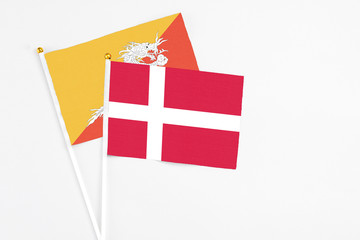Denmark and Bhutan stick flags on white background. High quality fabric, miniature national flag. Peaceful global concept.White floor for copy space.