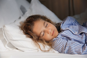 Cute little girl sleeping in bed at night