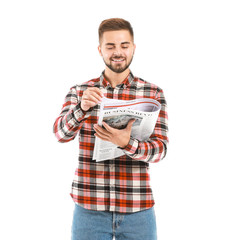 Handsome man with newspaper on white background