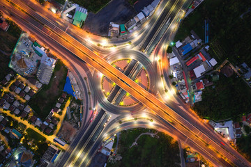 Aerial view of highway junctions Top view of Urban city, Bangkok at night, Thailand. Light trails across road junction, traffic abstract and transportation concept.