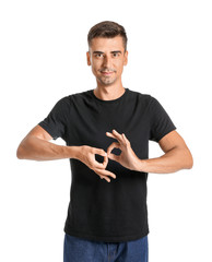 Young deaf mute man using sign language on white background
