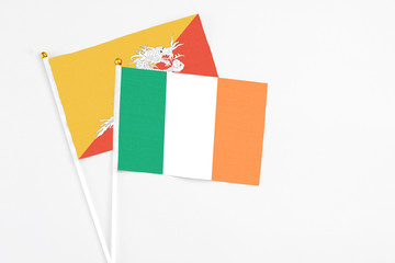 Ireland and Bhutan stick flags on white background. High quality fabric, miniature national flag. Peaceful global concept.White floor for copy space.