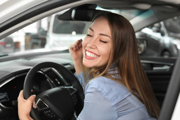 Happy female buyer sitting in new car