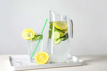 Fototapeta premium Jug and glass of healthy infused water on table