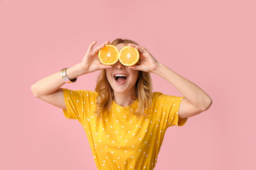 Funny mature woman with cut orange on color background