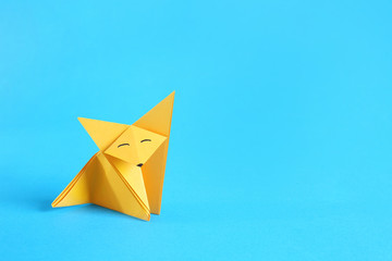 Origami fox on color background