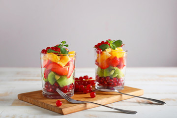 Glasses with tasty fruit salad on table