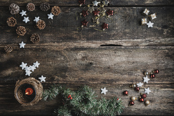 Top view of rustic wooden desk with holiday decorations, ornaments and candle placed on it