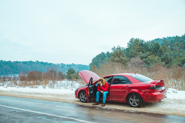 Obraz na płótnie Canvas man sitting in car calling for help. break down at winter speedway