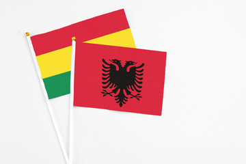 Albania and Bolivia stick flags on white background. High quality fabric, miniature national flag. Peaceful global concept.White floor for copy space.