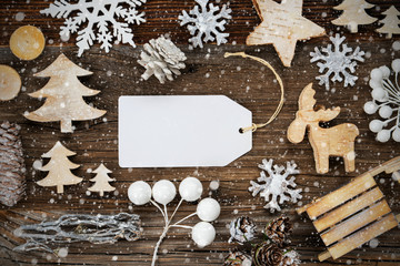 One White Label With Copy Space. Frame Of Christmas Decoration Like Tree, Sled, Star And Fir Cone. Wooden Background With Snowflakes