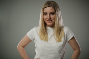 A cute blonde in a white t shirt stands