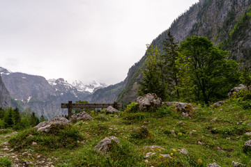 Fototapeta na wymiar bank am berghang in den alpen mit wolkenhimmel