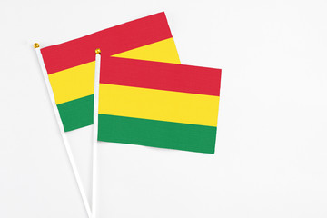 Bolivia and Bolivia stick flags on white background. High quality fabric, miniature national flag. Peaceful global concept.White floor for copy space.